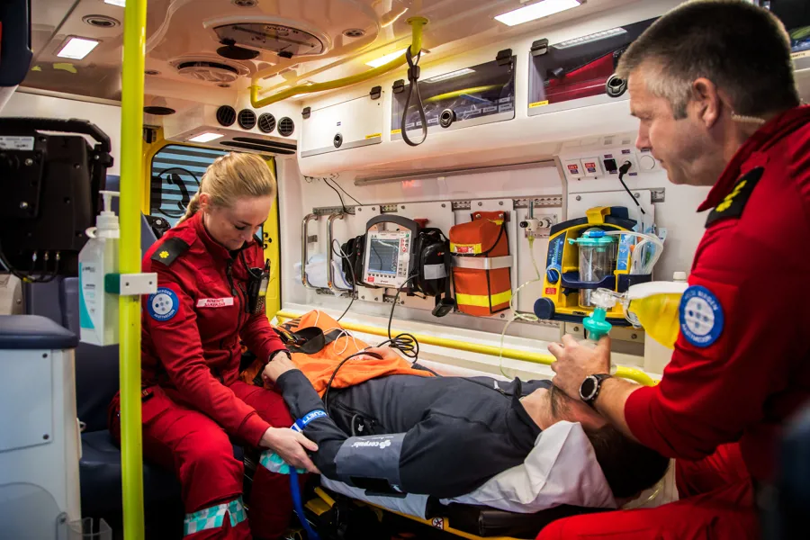 Pasient og ambulansearbeidere.