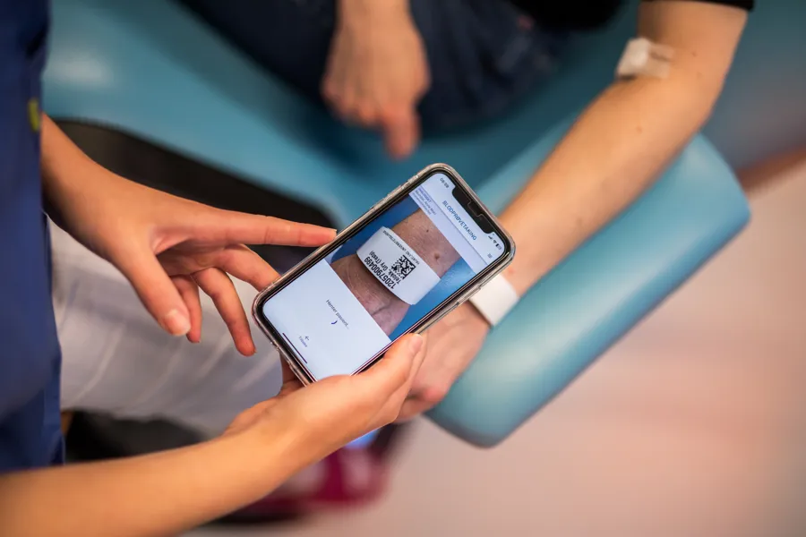 Hender som bruker en app på en telefon.