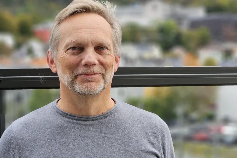 En mann med skjegg og grått hår