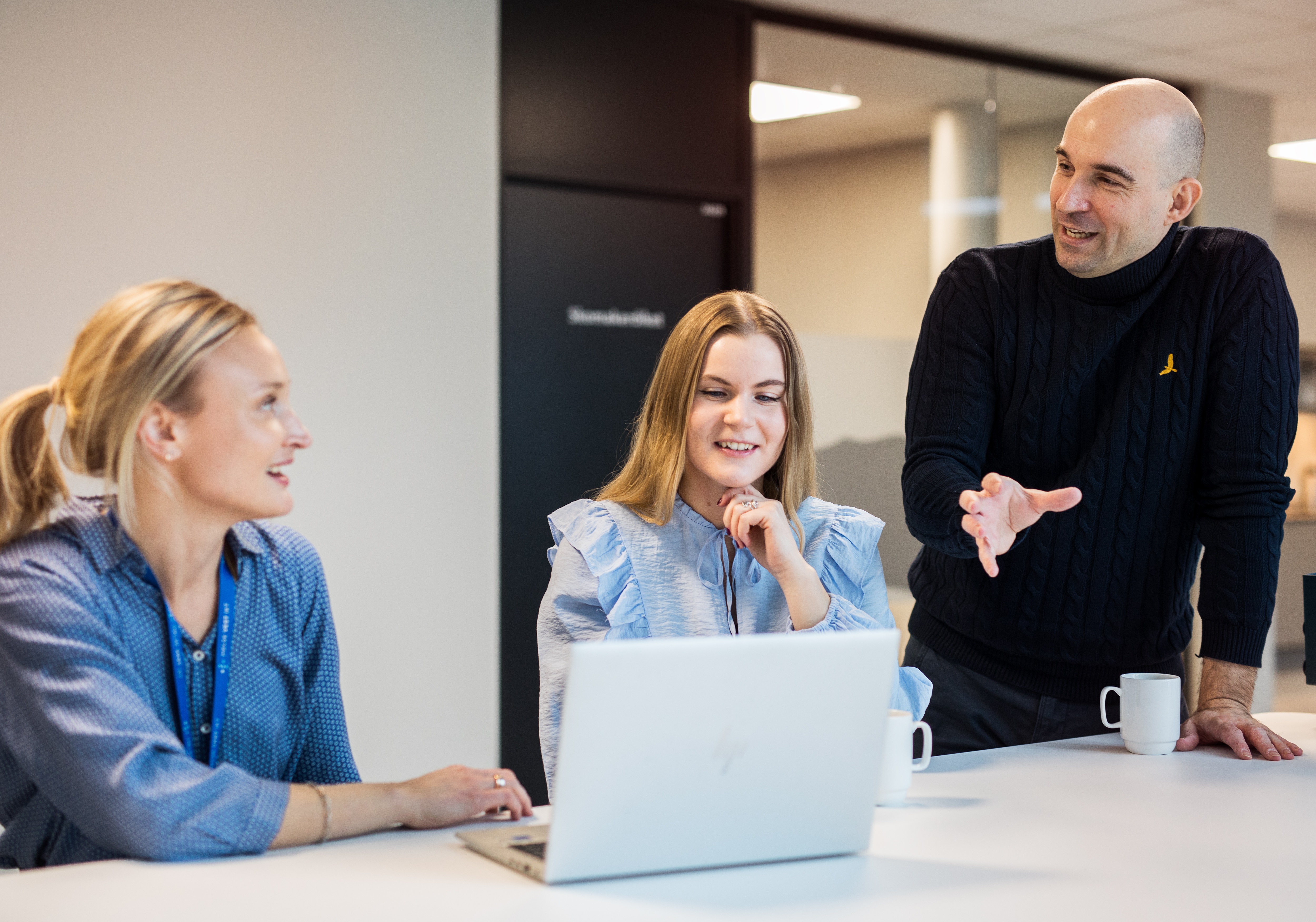 Tre personer diskuterer