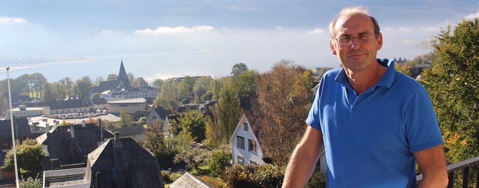 En mann som står på en balkong med utsikt over en by