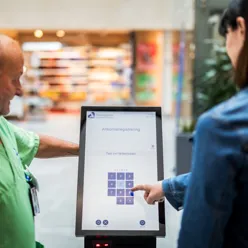 eldre mann hjelper pasient med skjerm