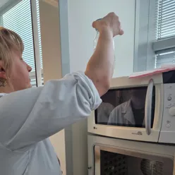 En mann åpner en mikrobølgeovn