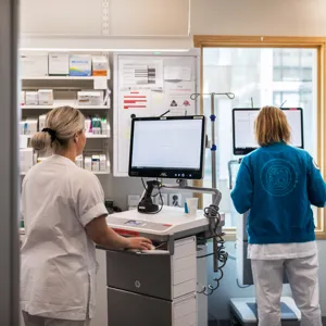 To kvinner kvar hver sin maskin på traller