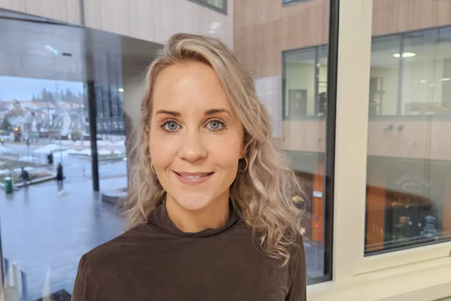 En kvinne som smiler til kameraet