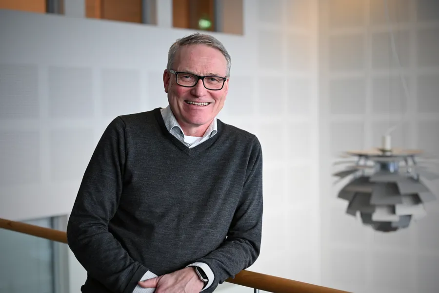 Mann med briller og grå genser