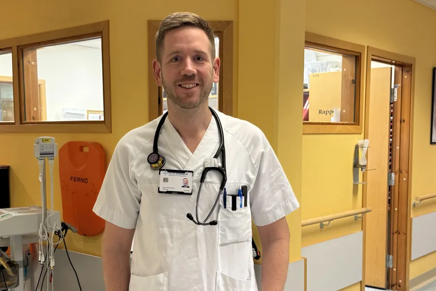 En mann iført hvit skjorte og stetoskop