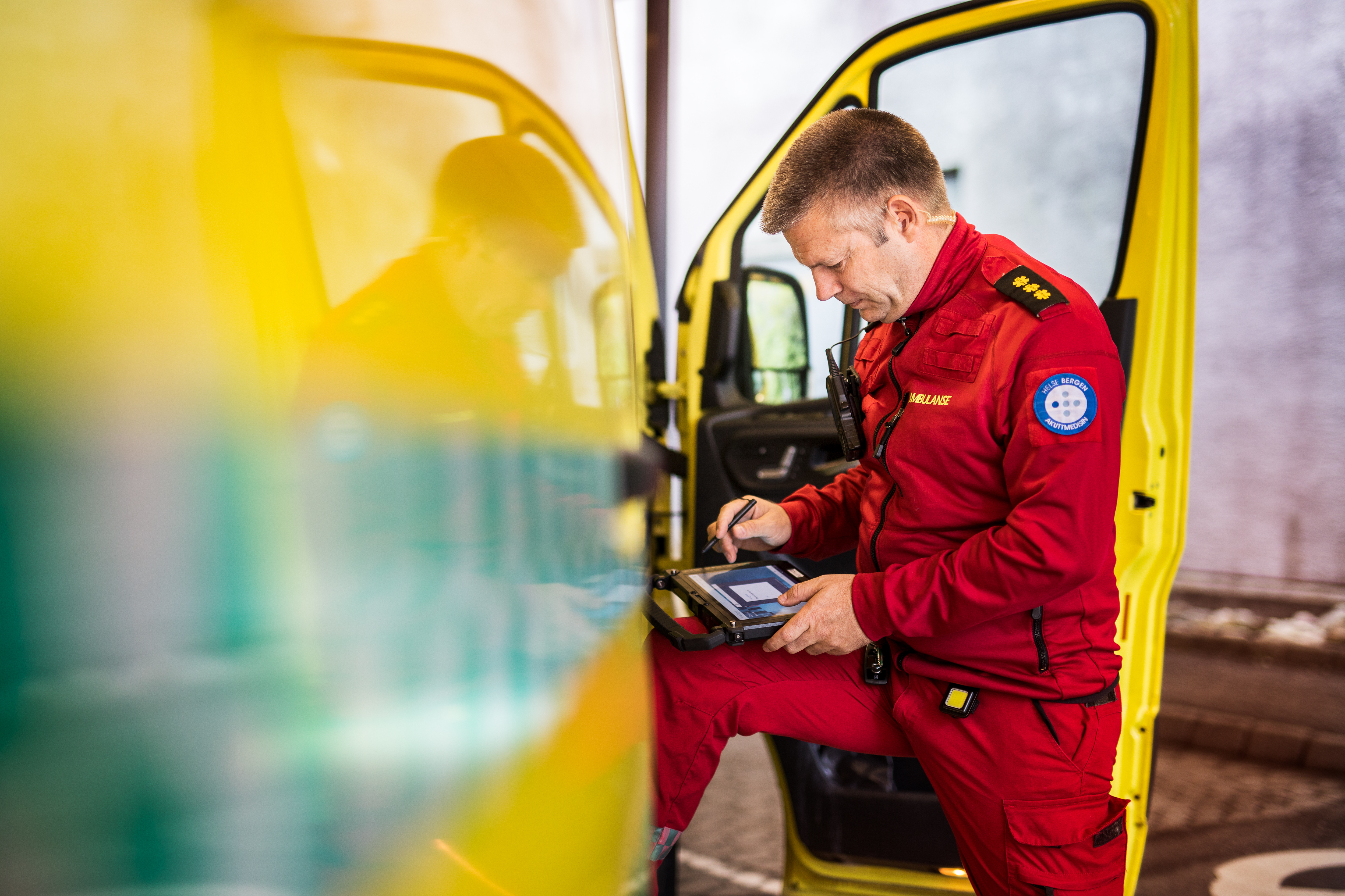 Mann står fremoverlent inn i ambulanse