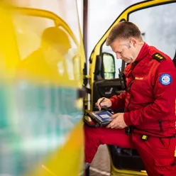 Mann står fremoverlent inn i ambulanse