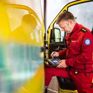 Mann står fremoverlent inn i ambulanse