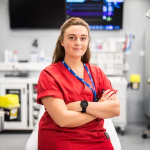 Kvinne sitter foran sykeseng