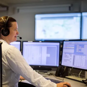 Dame betjener telefon på AMK-sentralen.